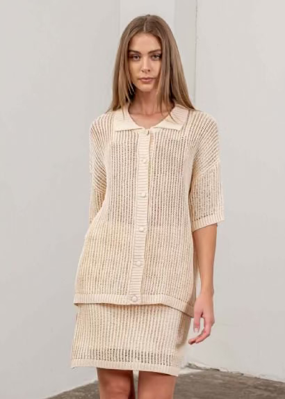 Cream ribbed knit button-down top with three-quarter sleeves and layered hem detail.