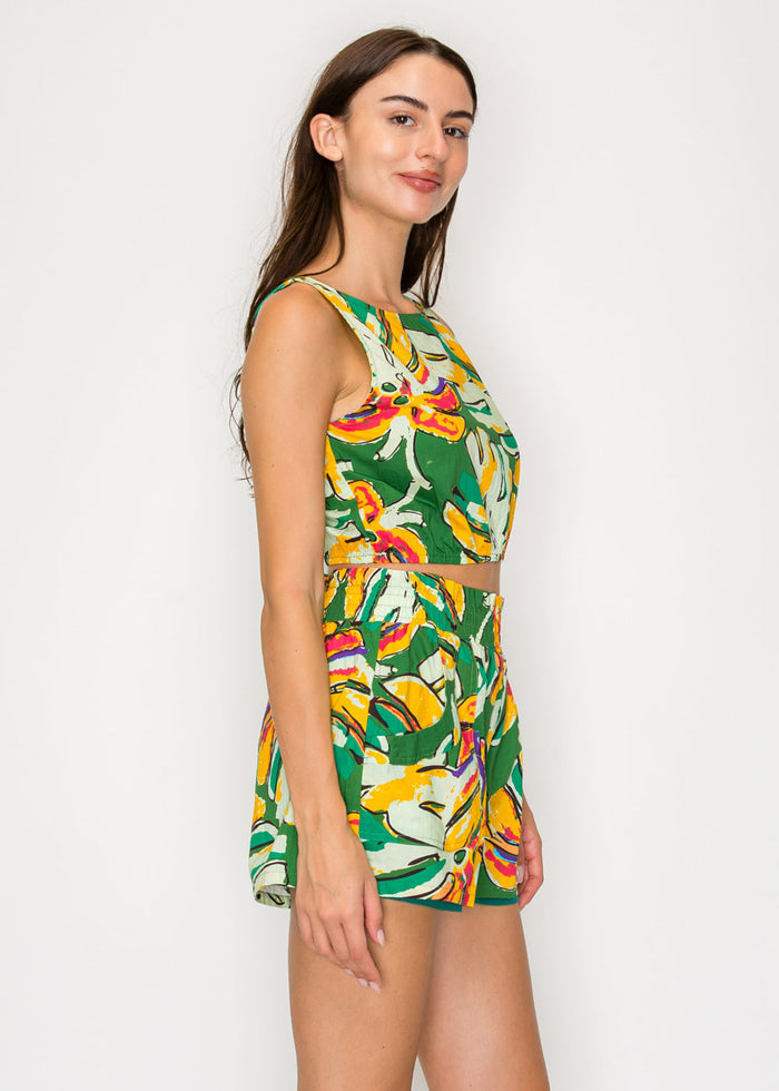 Woman wearing a colorful tropical print dress on a white background