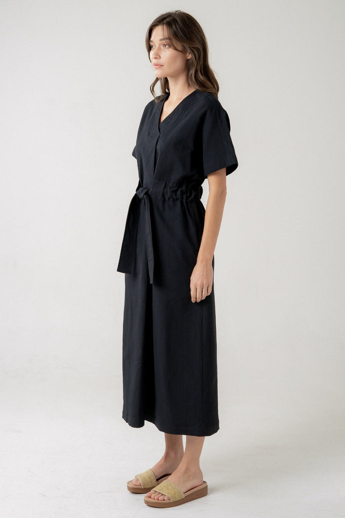 Black midi dress with short sleeves, V-neckline, and tie waist detail.