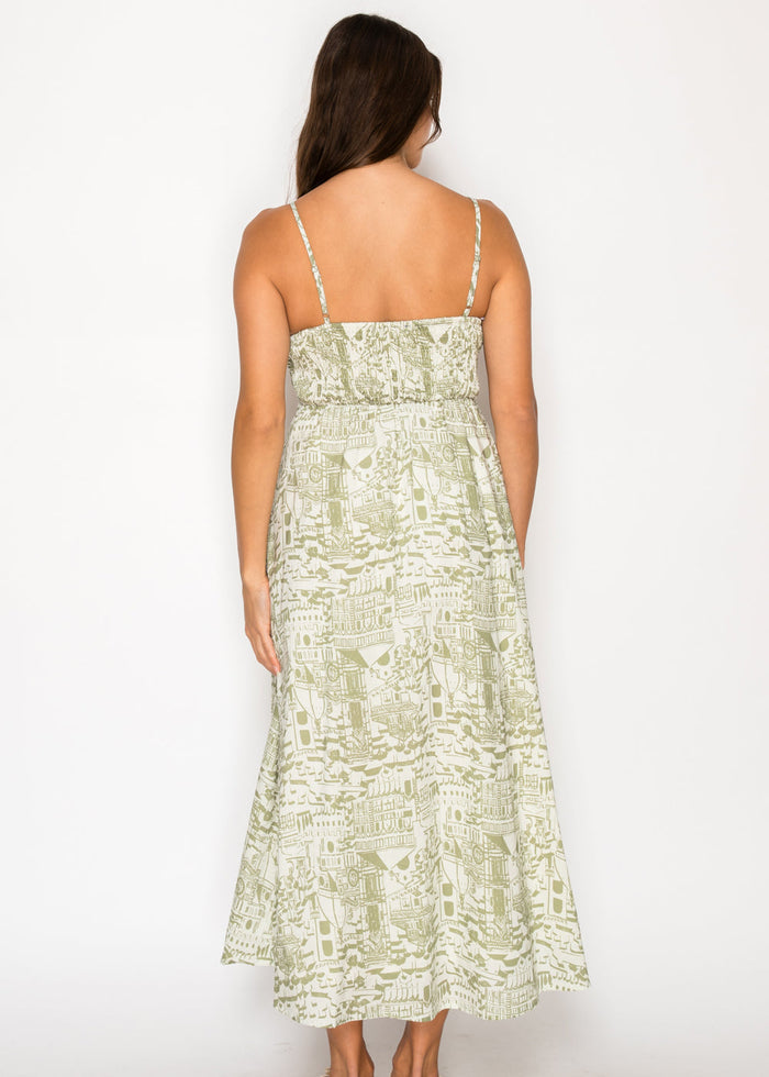 Cream and sage green maxi dress with architectural print, thin straps, and fitted bodice shown from back.