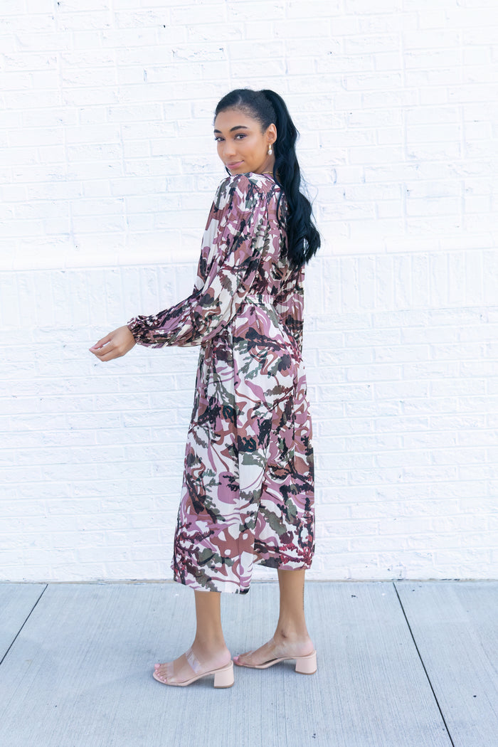 Long-sleeve midi dress with burgundy and pink abstract floral print, worn with pink block heel sandals.