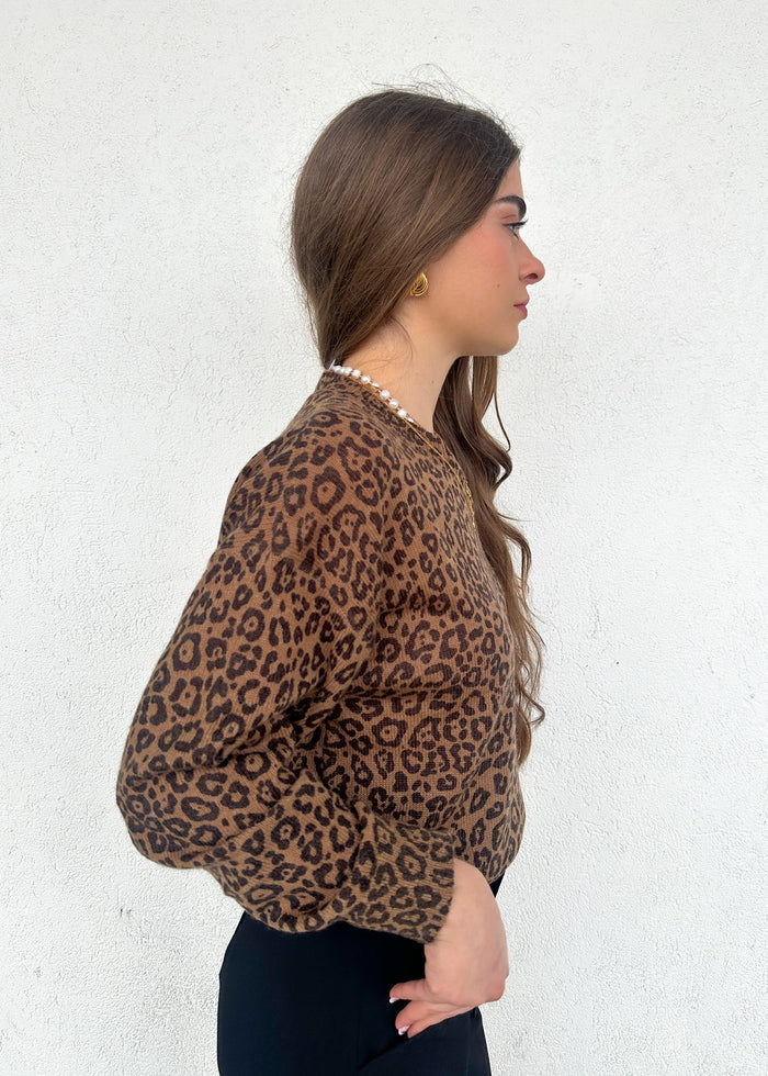 Tan and brown leopard print crewneck sweater worn by model shown from the side.