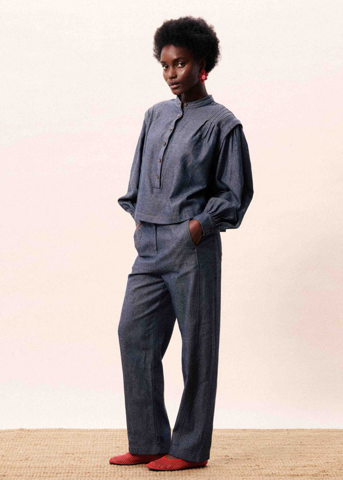 Navy blue button-front shirt with puffed sleeves and matching wide-leg trousers, shown on model.
