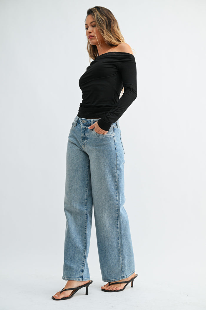 Light blue wide-leg jeans with a high waist and straight fit, paired with a black off-shoulder long-sleeve top.