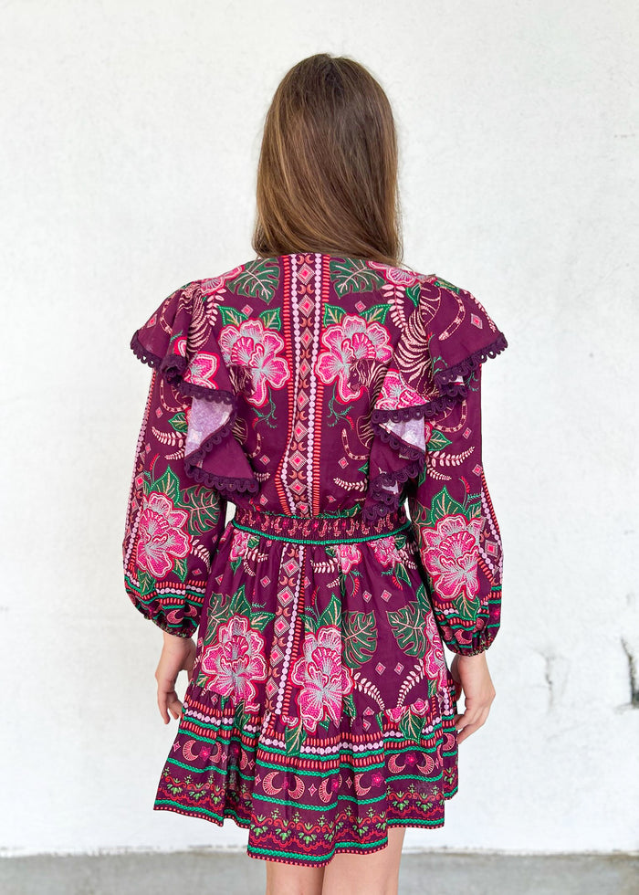 Burgundy mini dress with pink floral embroidery, ruffled cap sleeves, and long balloon sleeves, worn by a model shown from be