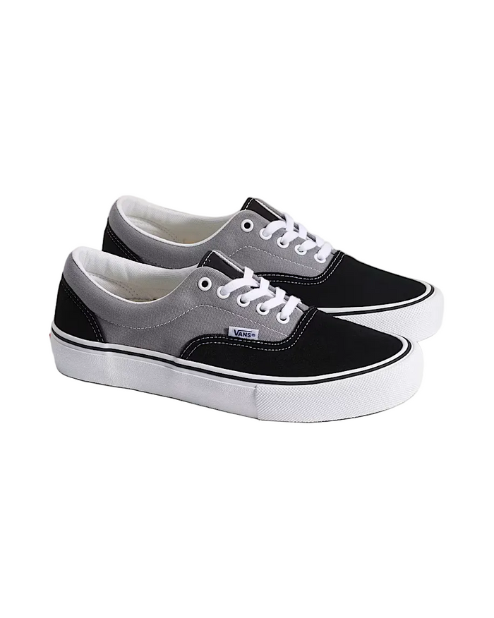 Pair of black and gray Vans sneakers on a light background