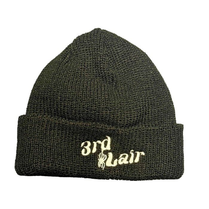 Black knit beanie with '3rd Lair' embroidery on a gray surface