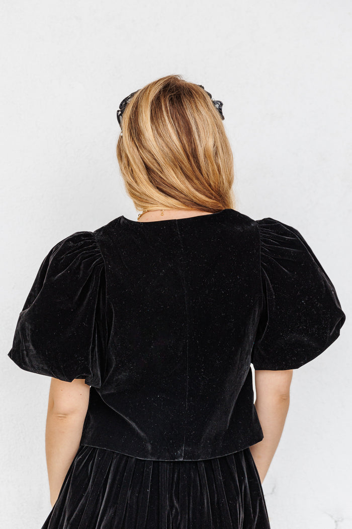 Black velvet top with short puffed sleeves, shown from back view on a model.