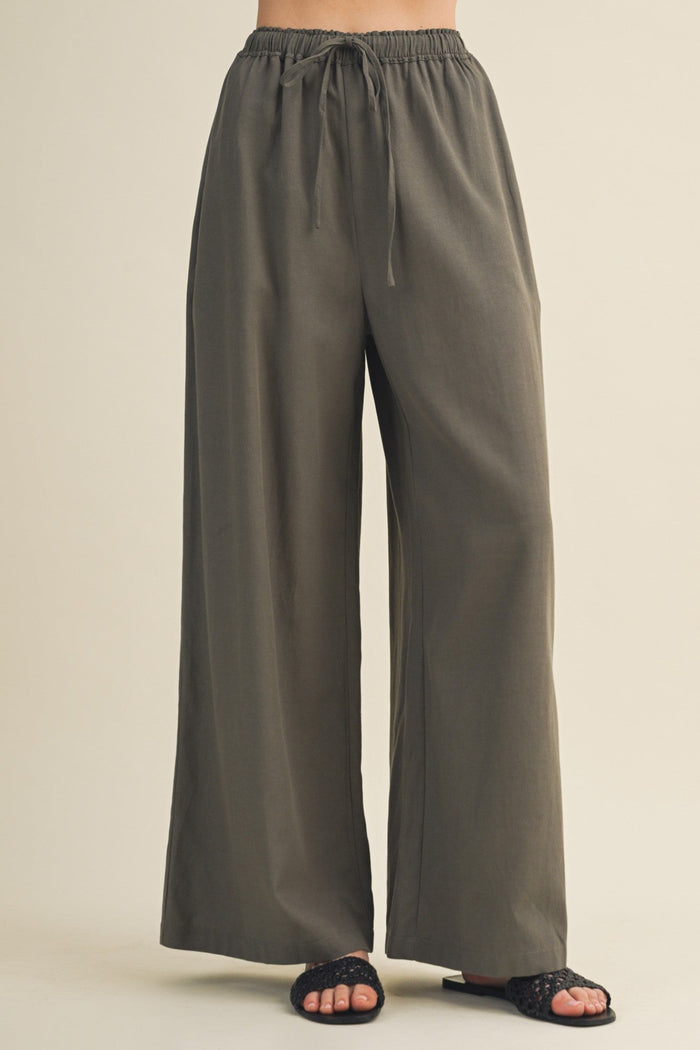 Olive green wide-leg pants on a beige background