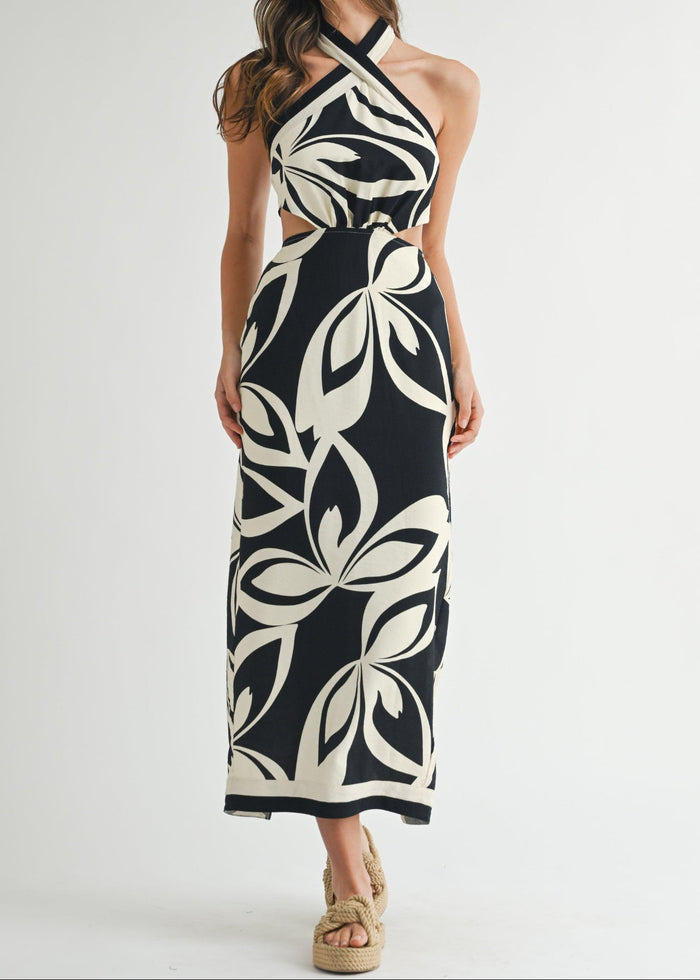 Black and cream halter midi dress with abstract leaf pattern and cutout waist detail.