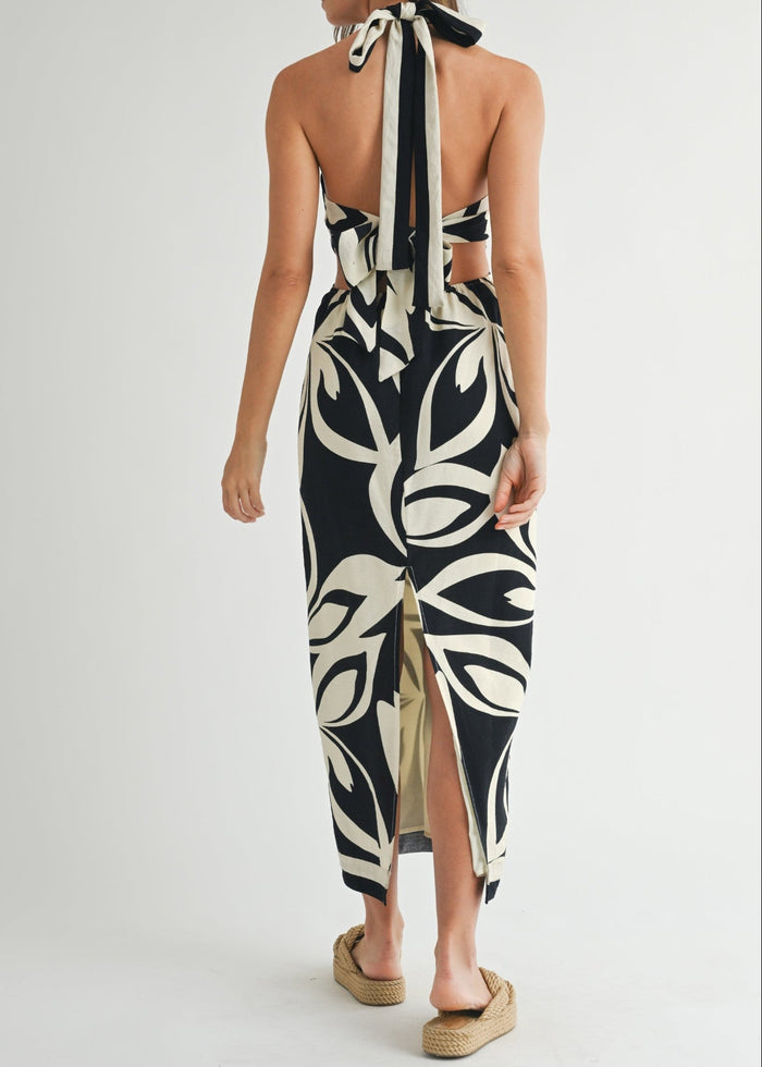 Black and cream abstract print halter midi dress with cutout back and front slit detail.