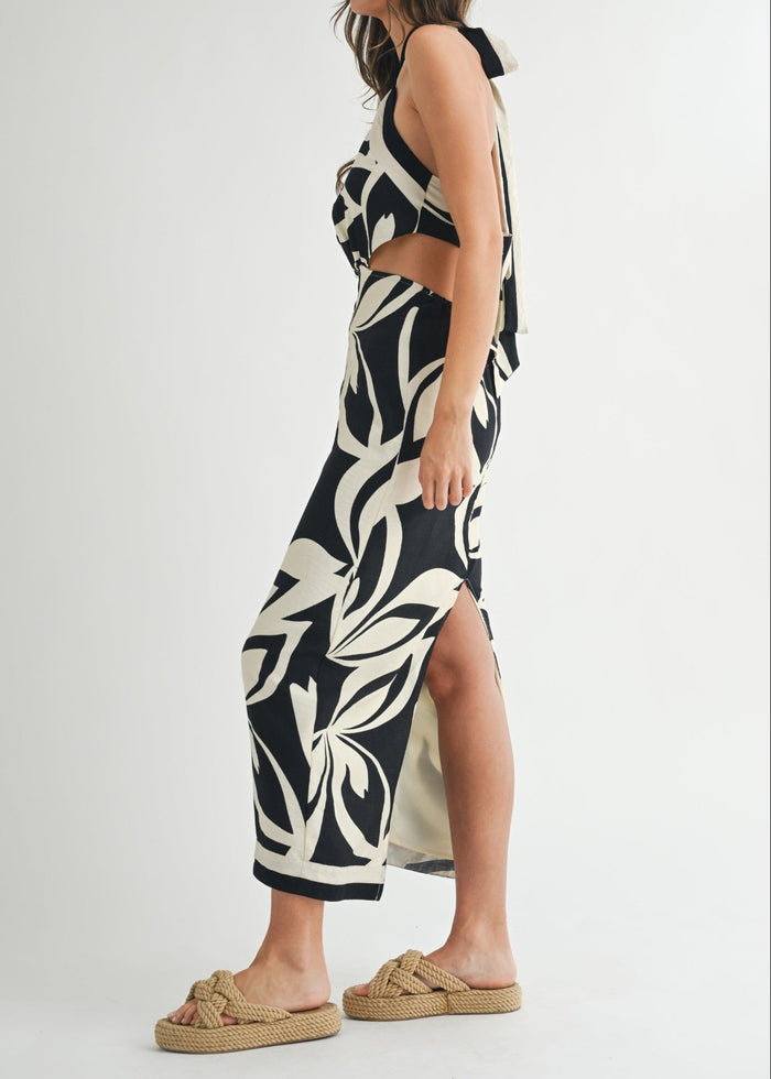 Black and cream abstract leaf print halter midi dress with cutout waist and side slit.