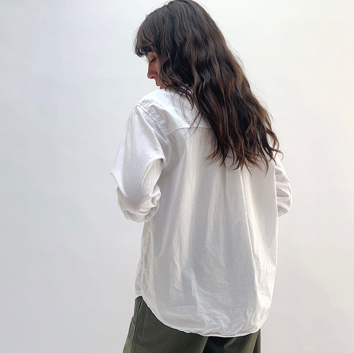 Alix Top in White — back view showing relaxed oversized fit and curved hem, styled with olive trousers