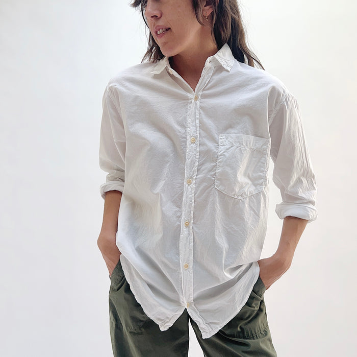 Alix Top in White — front view with hands in pockets, highlighting chest pocket detail and relaxed drape in white cotton