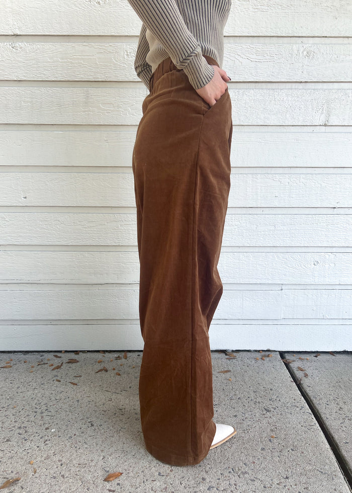 Brown corduroy pants with side pockets, worn with gray ribbed sweater and white sneakers.