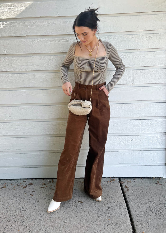 Brown corduroy pants with a high waist and straight leg silhouette, styled with a gray ribbed top.