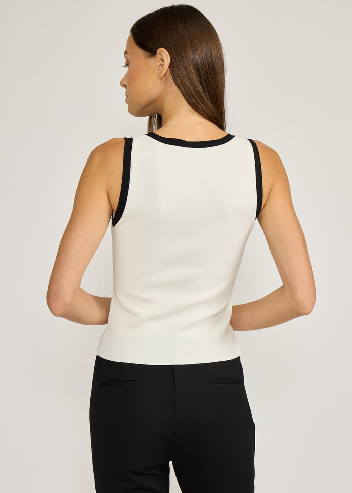 White ribbed tank top with black trim at neckline and armholes, shown on model from back view.