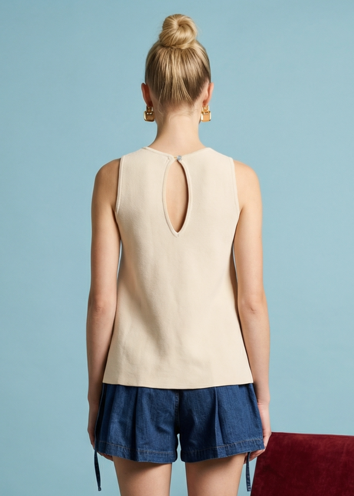 Cream sleeveless linen top with keyhole cutout at center back, shown from rear view on model.