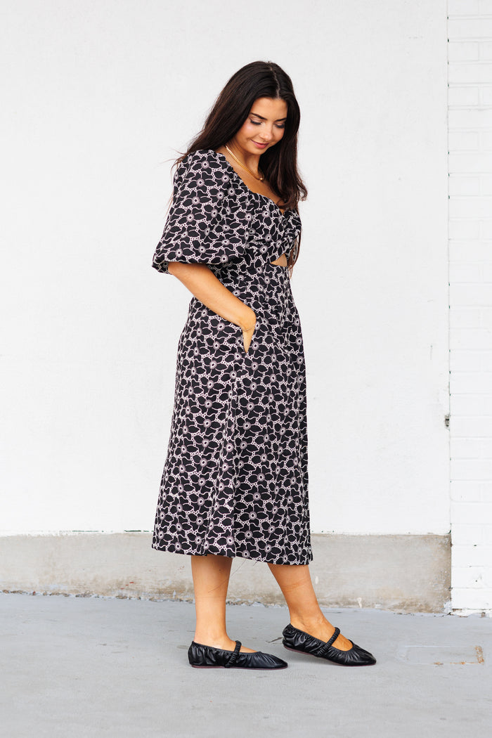 Black and white geometric patterned midi dress with short flutter sleeves and side pockets.