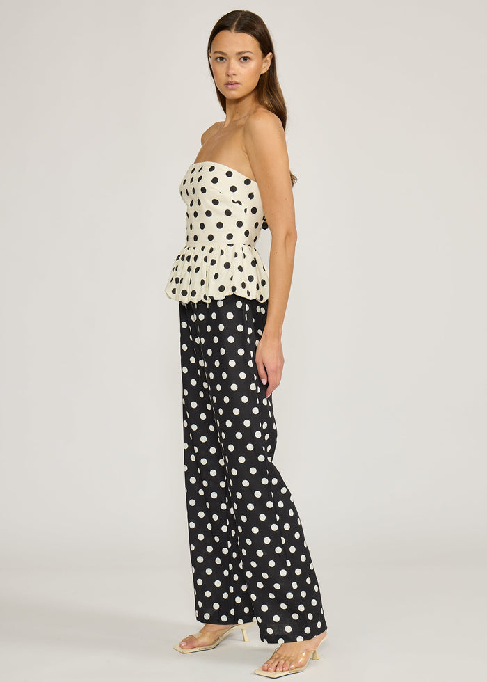 Strapless peplum top in cream with black polka dots worn with matching black polka dot pants.
