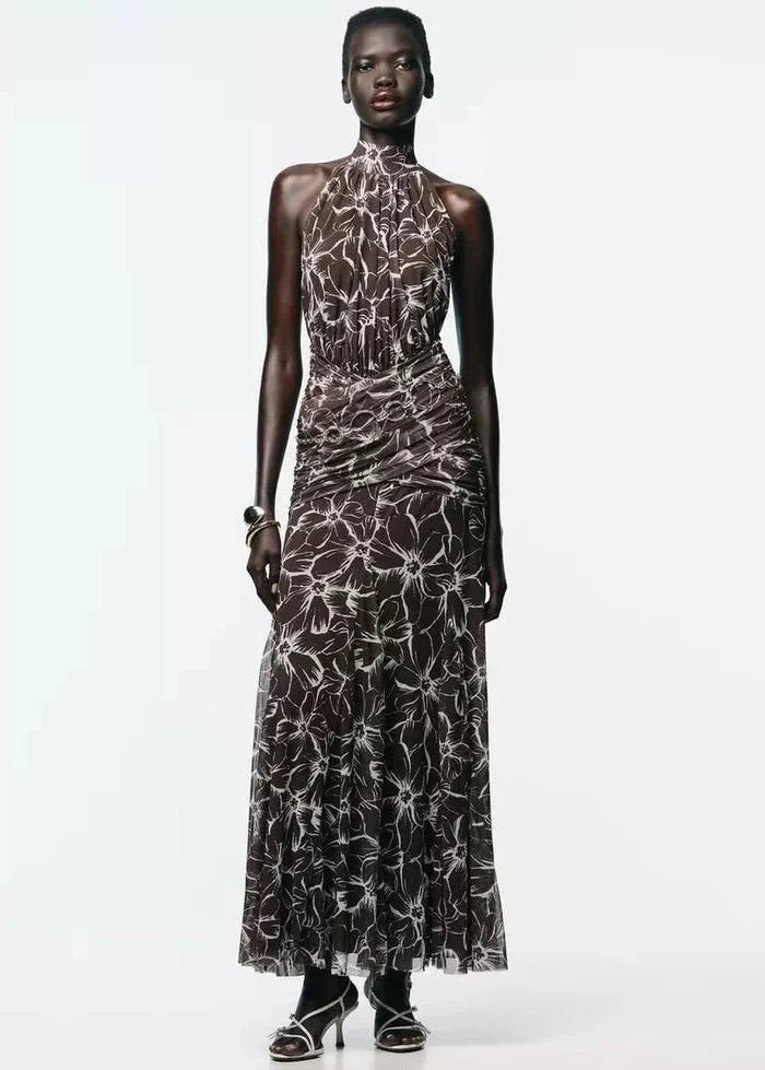 Black halter maxi dress with white floral print and ruched waist detail.