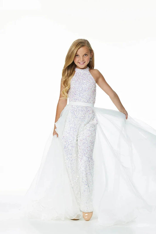 Young girl models an ivory organza overskirt atop a stretch glitter jumpsuit.