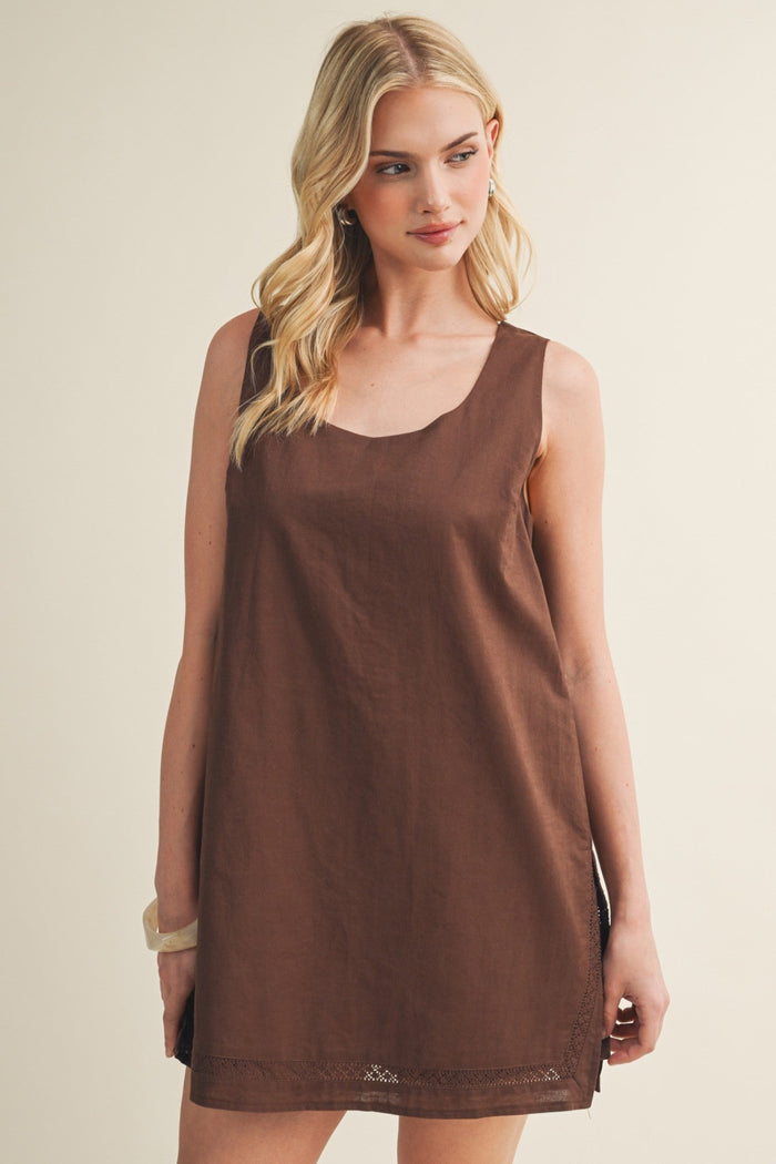 Brown sleeveless dress romper with scoop neckline and lace trim at hem.