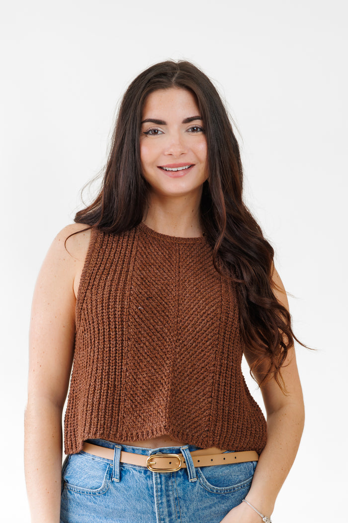 Brown ribbed knit sleeveless top with crew neckline worn with blue jeans and tan belt.