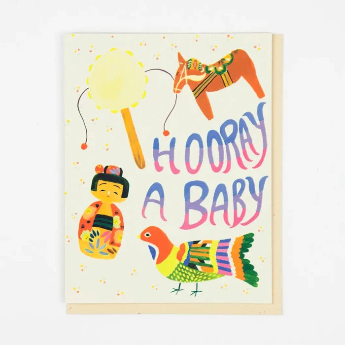 Colorful baby shower card with toys and 'Hooray A Baby' text on a light background
