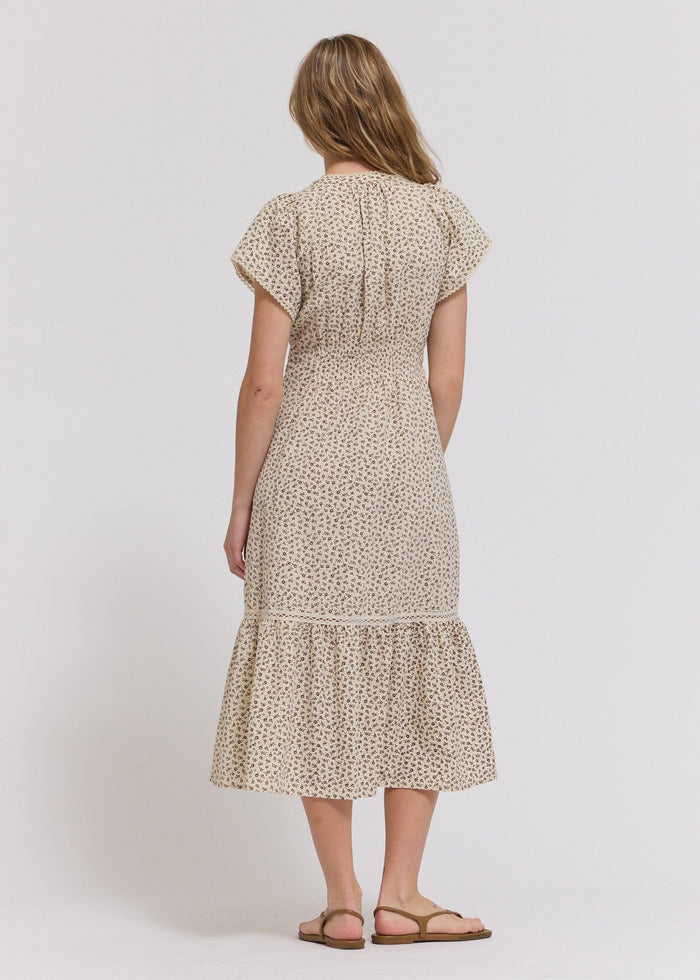 Cream midi dress with small floral print, short sleeves, and tiered ruffle hem.