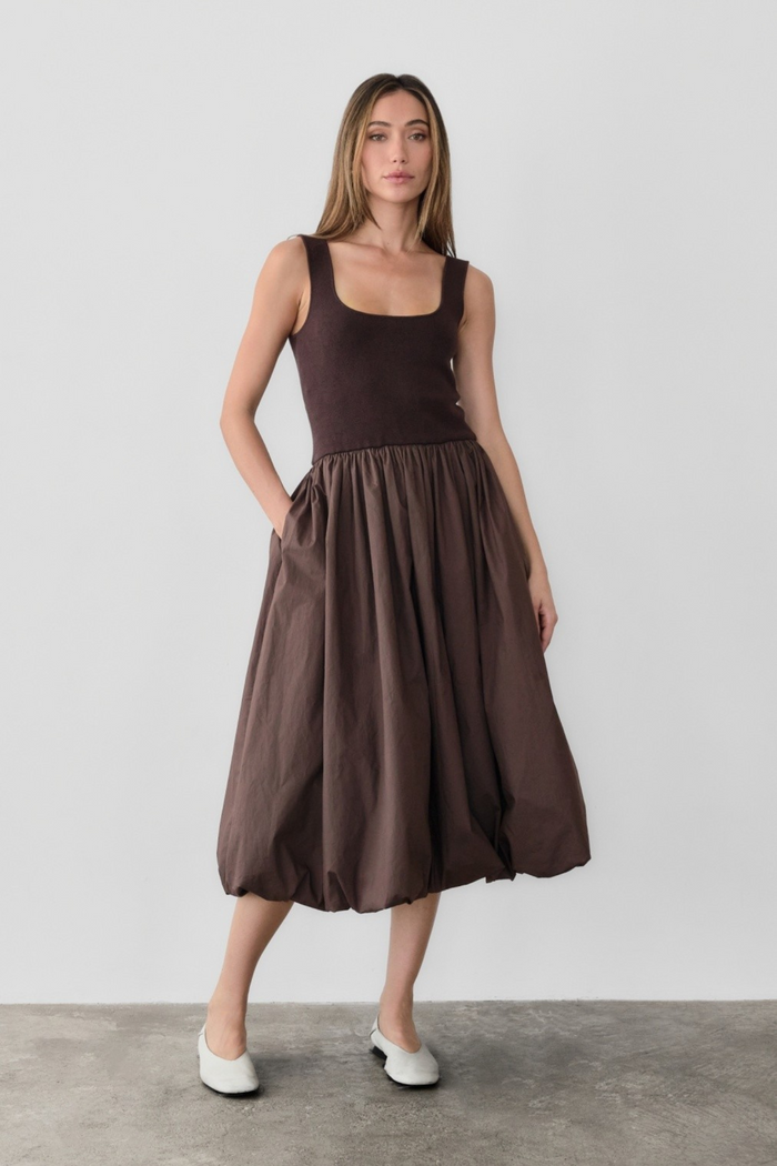 Brown sleeveless midi dress with square neckline, fitted bodice, and full gathered skirt with side pockets.