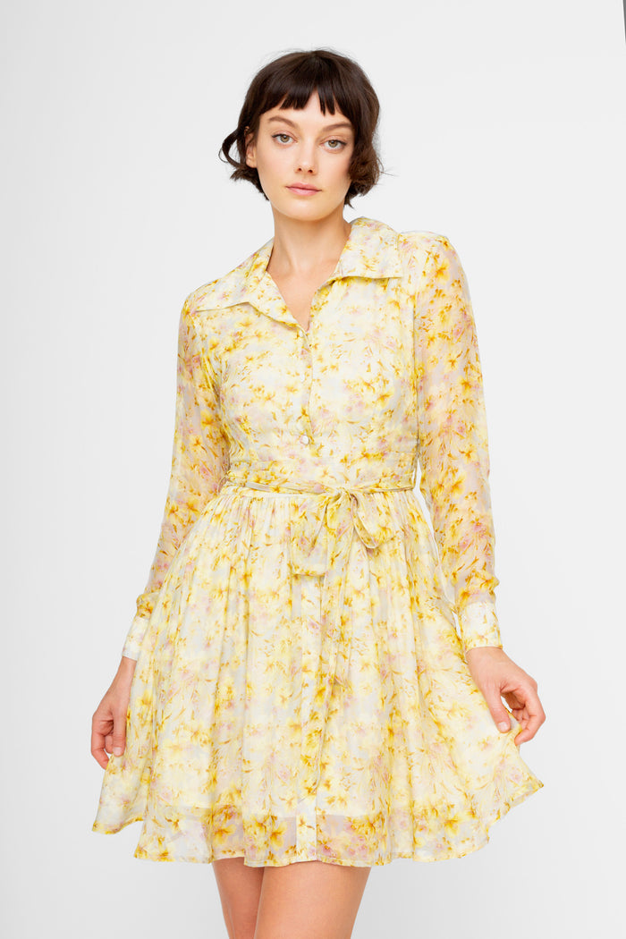 Yellow floral print shirt dress with long sleeves, collar neckline, and tied waist belt.