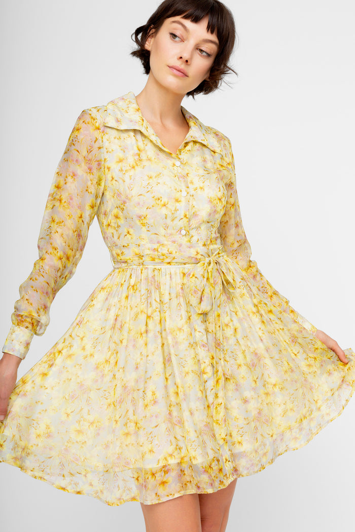 Cream and yellow floral print shirt dress with long sleeves, collar, and tie waist belt.
