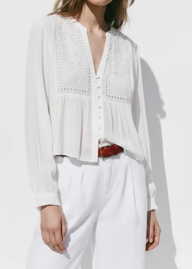 White long sleeve top with eyelet embroidery on front panels and button-down closure.