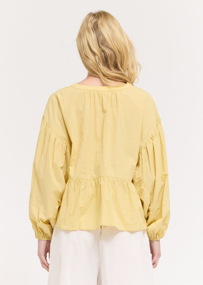 Yellow blouse with voluminous balloon sleeves and gathered waist detail, shown from back.