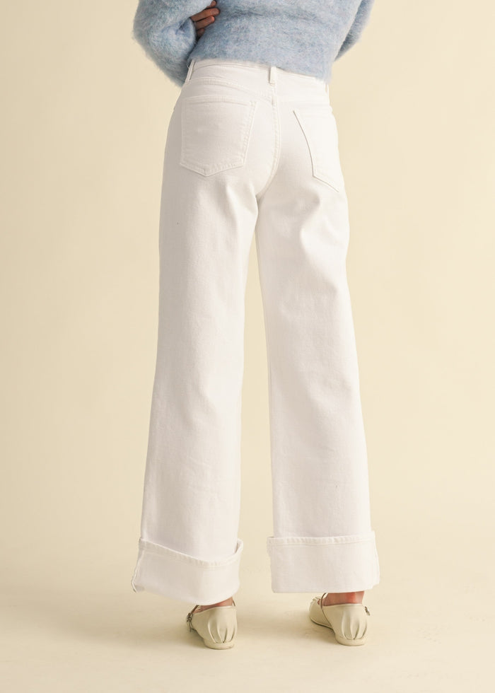 White wide-leg palazzo jeans with cuffed ankles, rear pockets, and high waist, shown from back view.