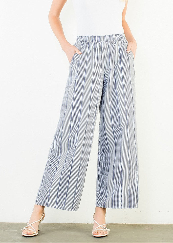 Woman wearing a white t-shirt and blue striped pants on a white background