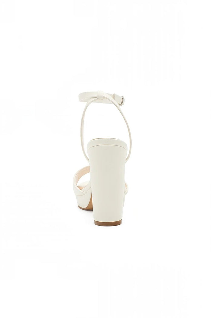 RSG Formals DeBlossom Jane white block heel sandals with an adjustable ankle strap, shown from the back view.