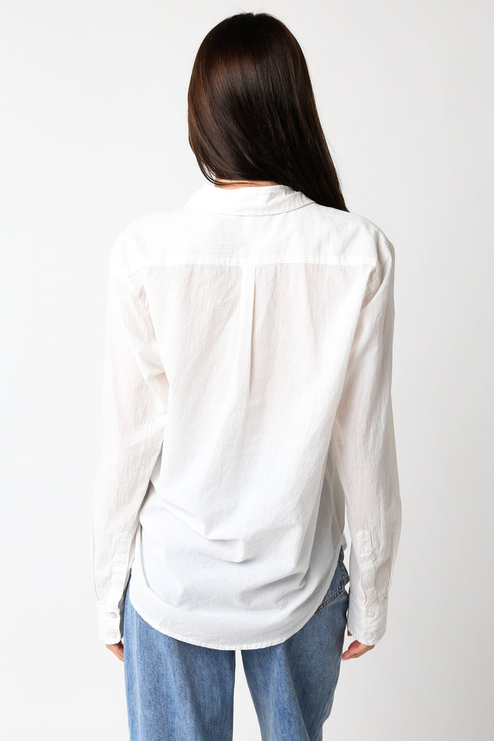 White button-down top with long sleeves and a collared neckline, shown from the back on a model.