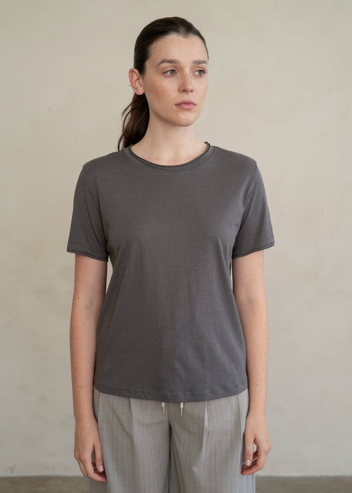 Charcoal gray short-sleeve t-shirt with crew neckline worn with gray pinstriped pants.