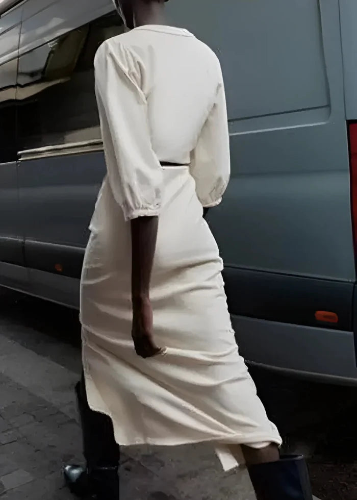 White button-front midi dress with puffed sleeves and cutout at waist, shown from back view.