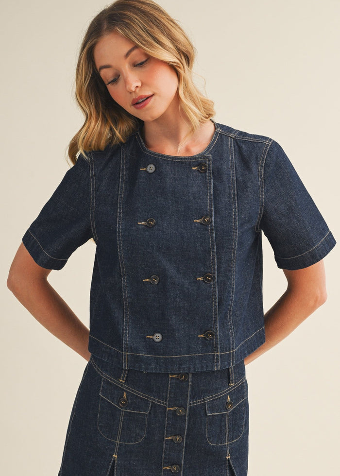 Woman wearing a denim dress with a plain background
