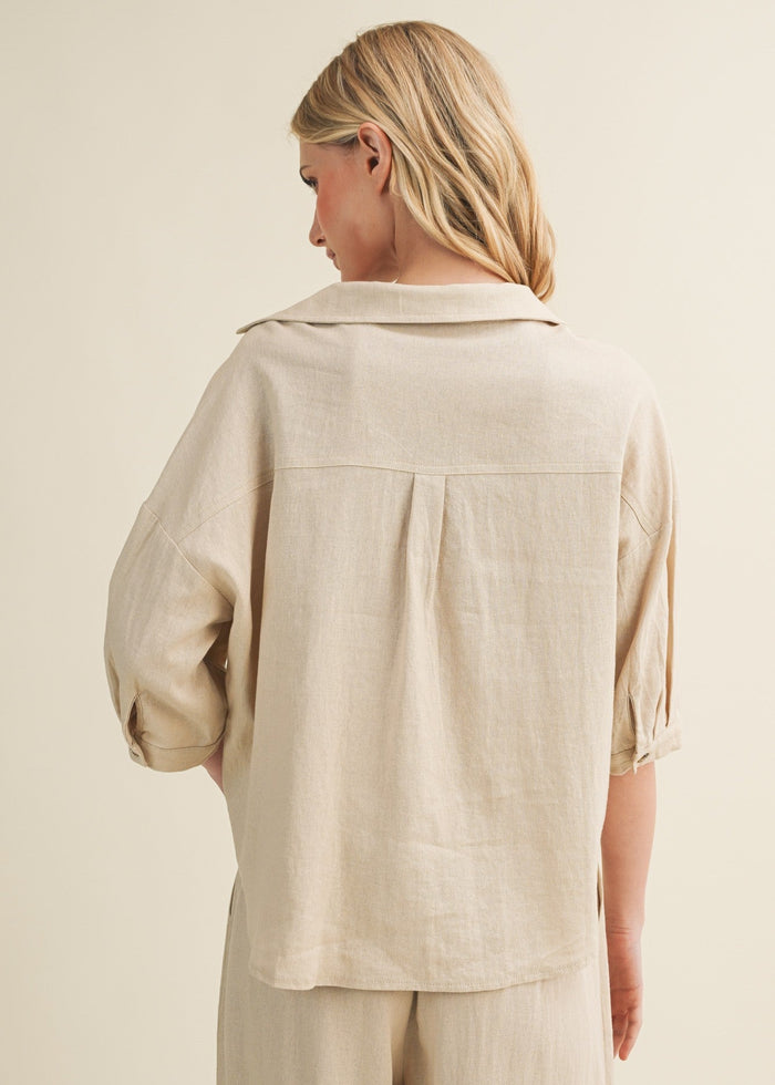 Beige linen button-up top with collar and three-quarter sleeves, shown from back on model.