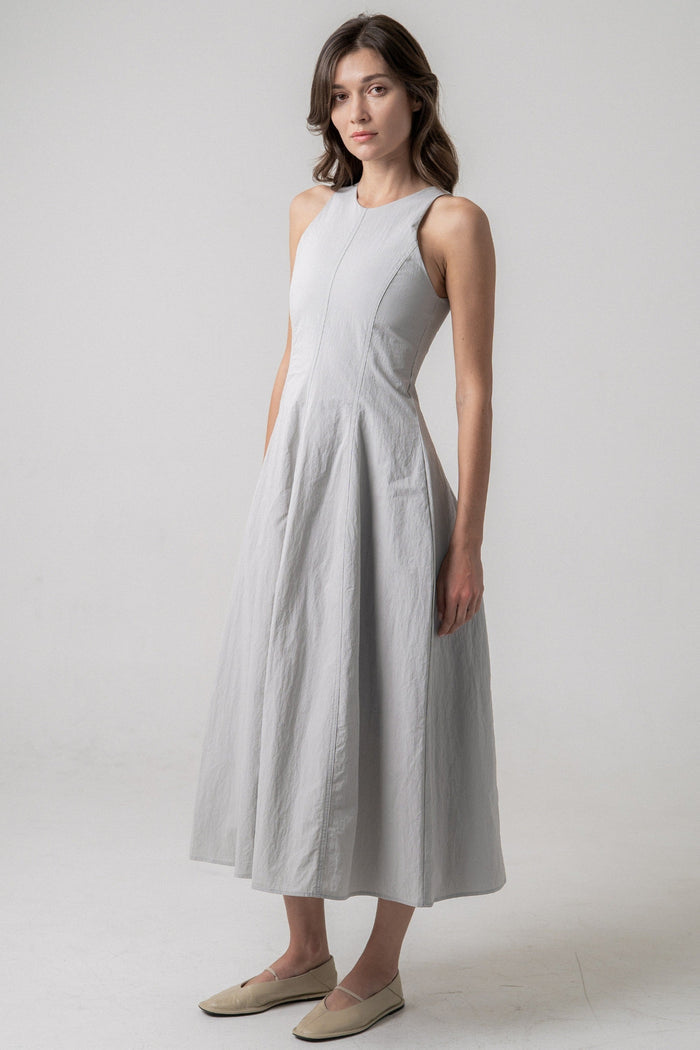 Light gray sleeveless midi dress with fitted bodice and flared skirt worn with tan slip-on shoes.