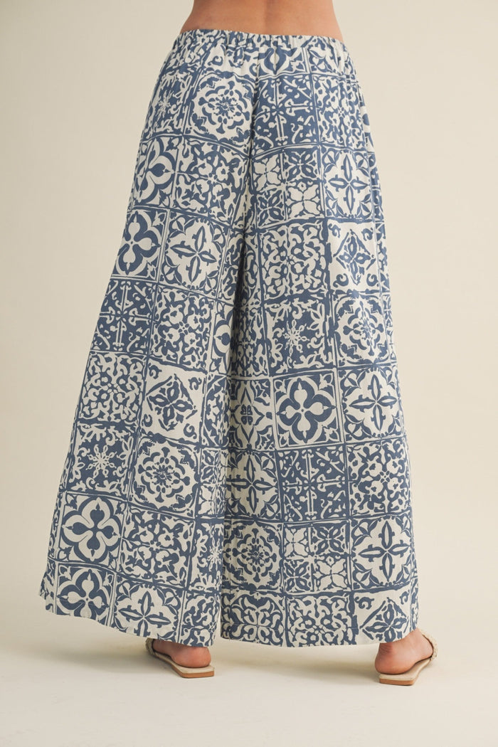 Blue patterned pants worn by a person on a beige background