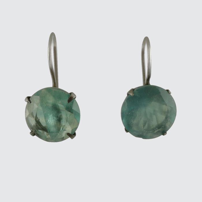 Pair of earrings with green gemstones on a light gray background