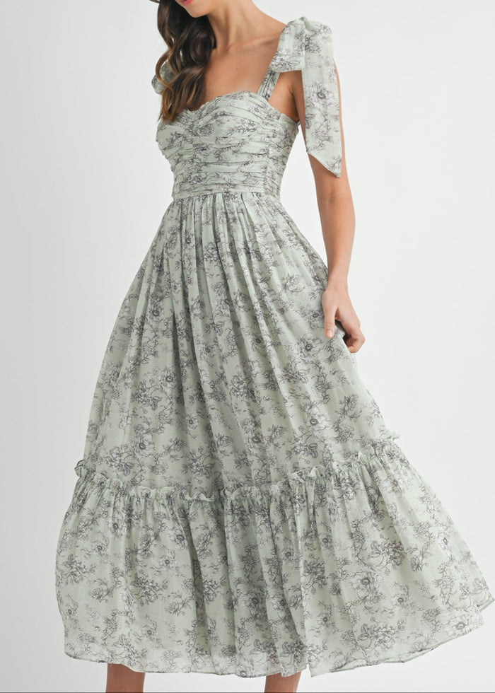 Sage green floral midi dress with ruched bodice, puff sleeves, and tiered skirt.