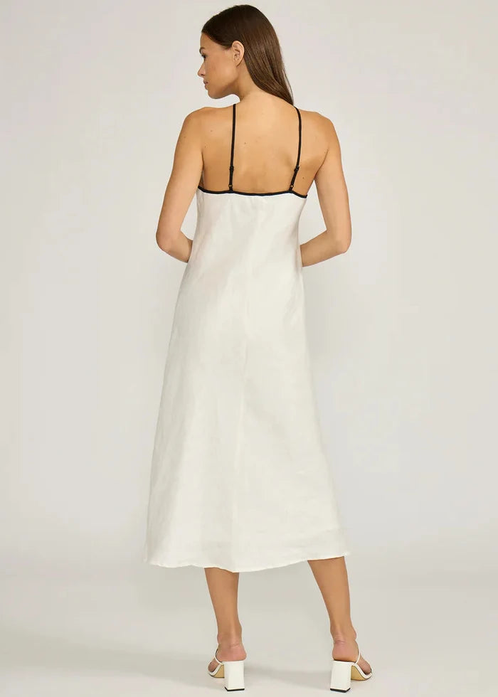 White halter midi dress with black trim neckline, open back, and A-line silhouette.
