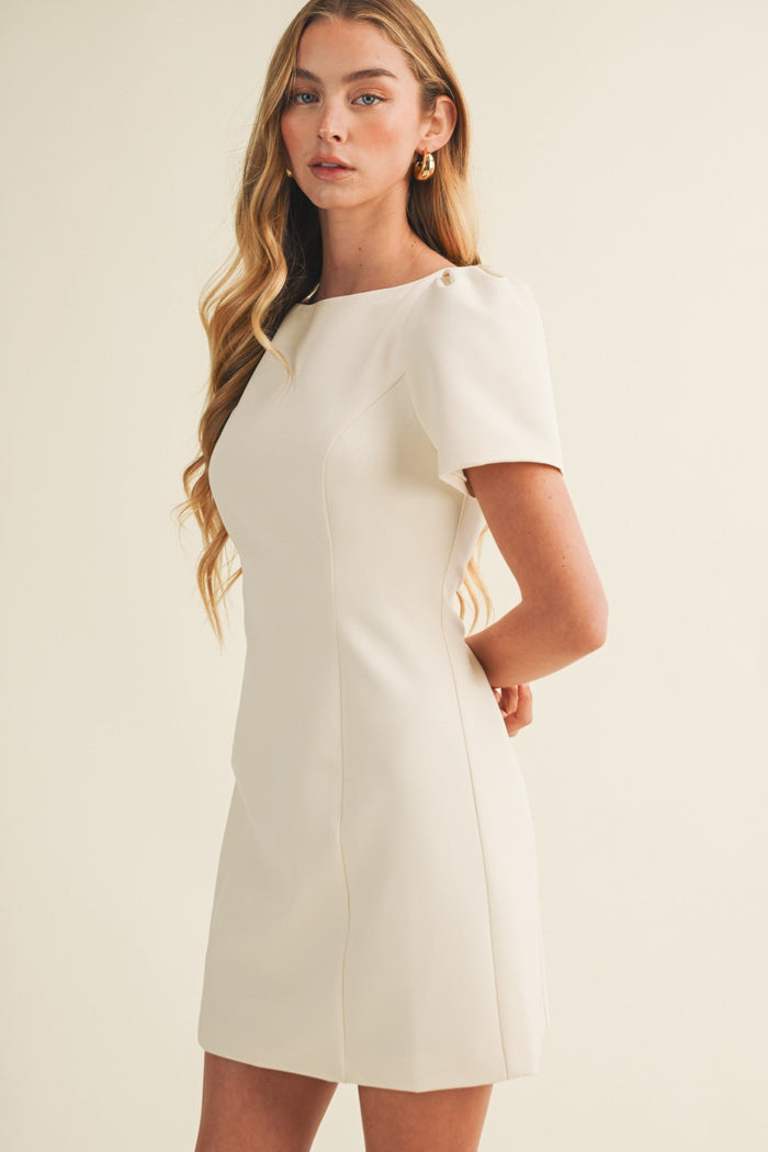Woman wearing a white dress against a plain background