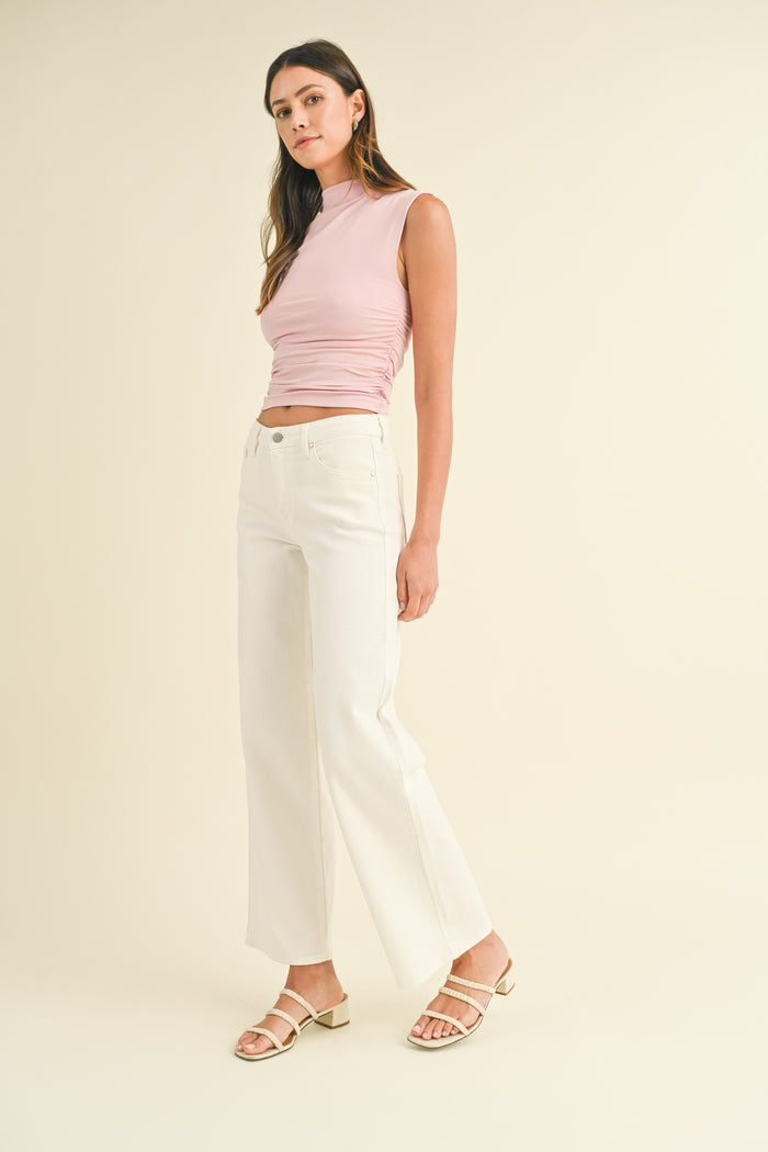 White wide-leg jeans with a high waist and straight fit through the leg, styled with a pink sleeveless top.